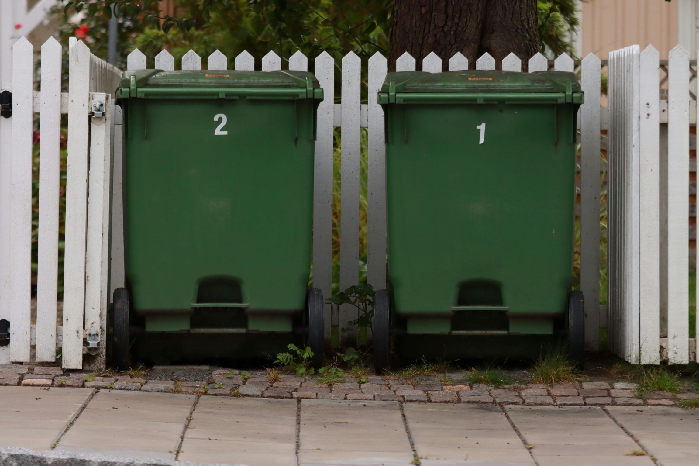 WasteGoGo team moving trash bins to the curb for scheduled pickup, ensuring a smooth waste disposal process.